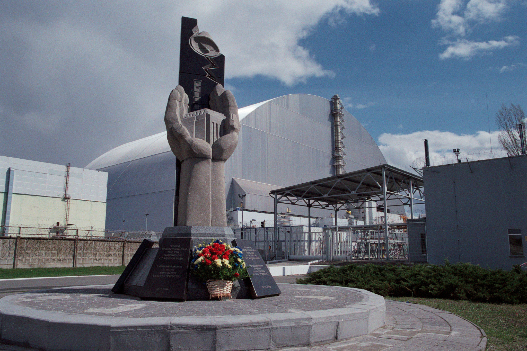 Protective confinement over the fourth power unit of the Chernobyl nuclear power plant. In front, a monument to the heroes who sealed the reactor at the cost of incredible efforts. Picture by Stanislav Nepochatov. CC BY-SA 3.0