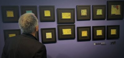 Una persona observa una selecció de vinyetes emmarcades de la campanya #NoteOlvides en una exposició d’ISGlobal.